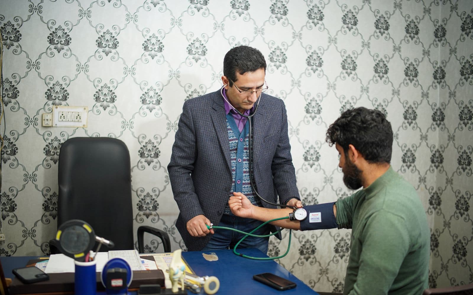 Doctor checking a patient’s blood pressure during a consultation at a clinic in Pakistan