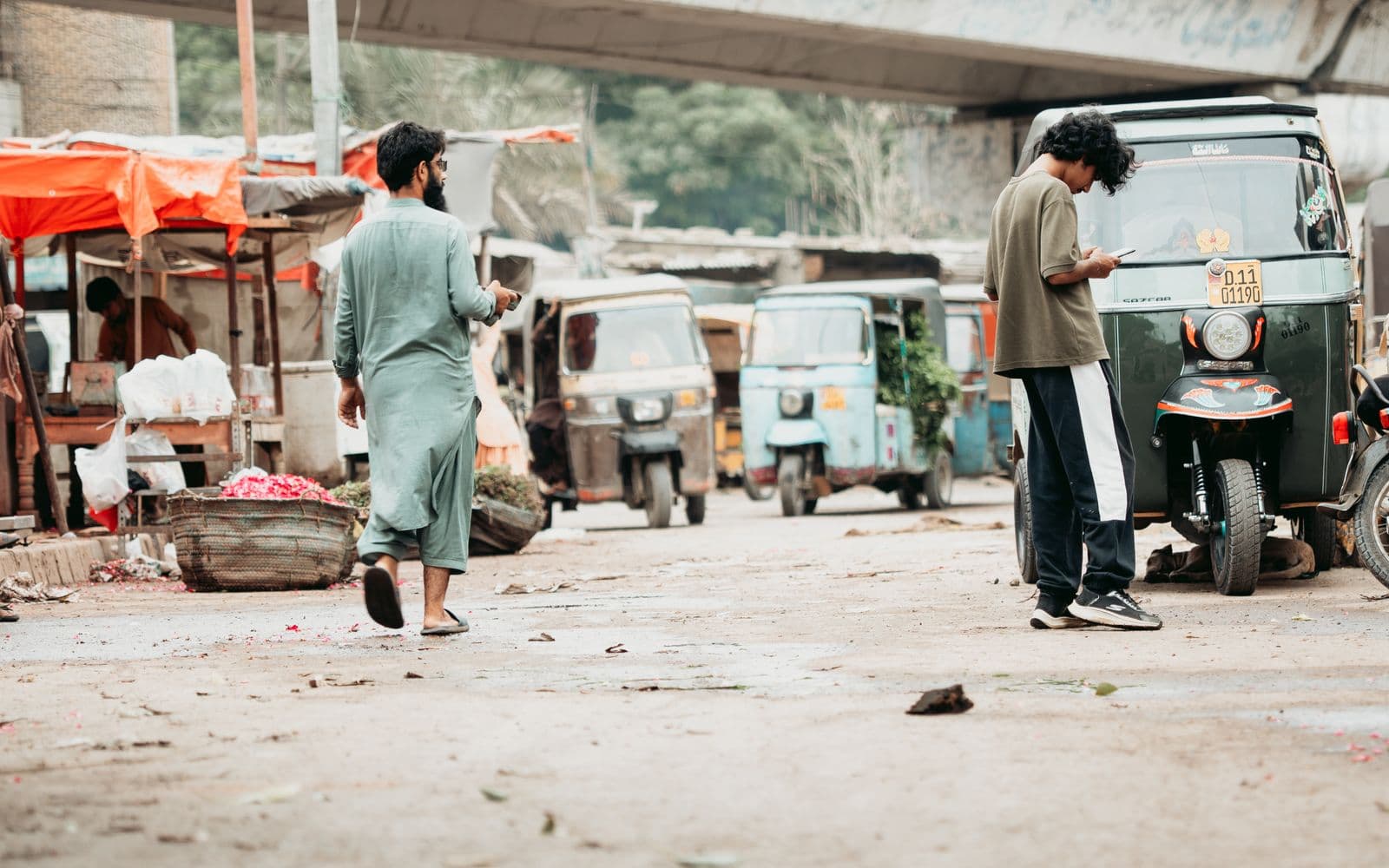 Busy Karachi street with rickshaws, market stalls and shoppers
