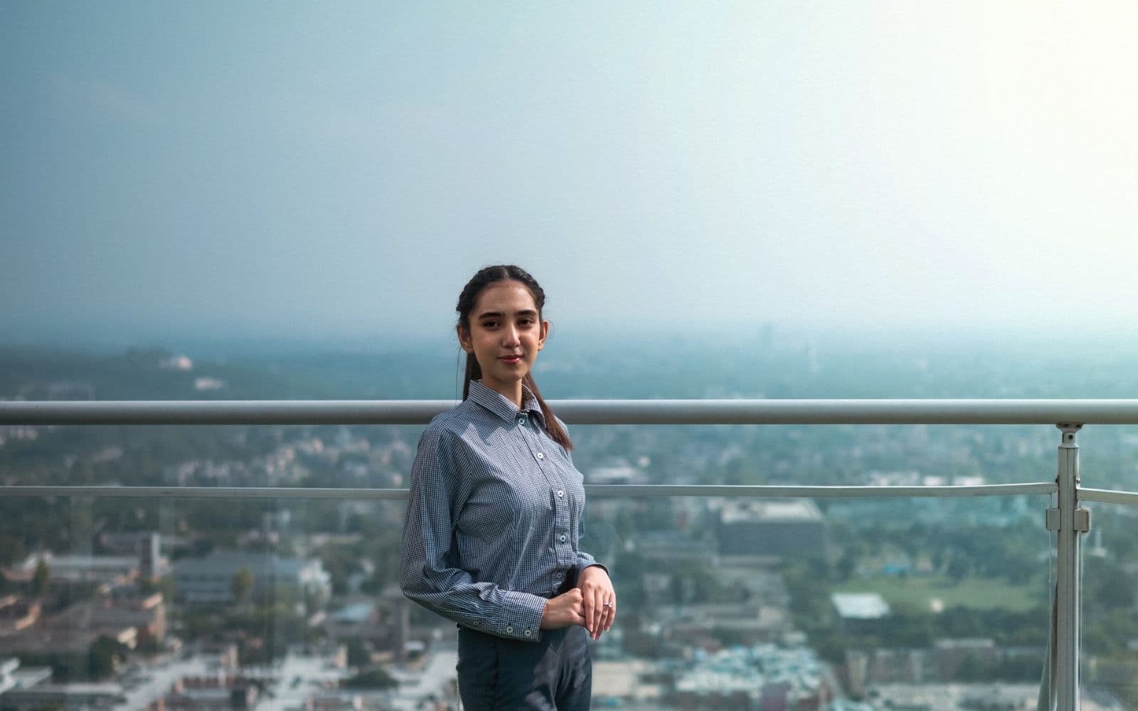Young Pakistani professional woman standing on a rooftop above the Islamabad skyline