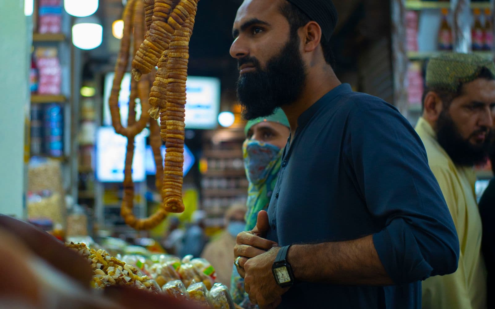 Busy market shop in Karachi with a shopkeeper serving customers