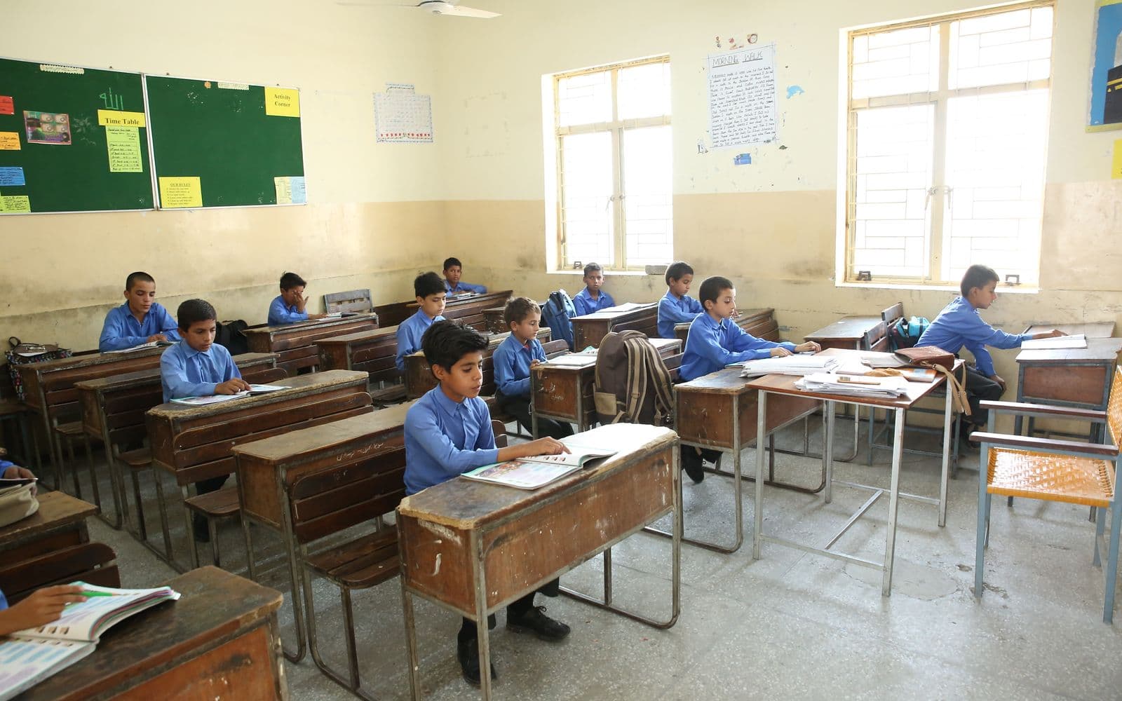 Pakistani school classroom with students in blue uniforms at their desks